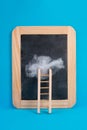 Ladder with a cloud on top, blank chalkboard, blue colored background, copy space, dreaming of success, creative and business