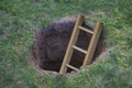 Ladder coming out of a hole in the ground Royalty Free Stock Photo