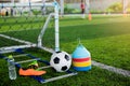 Ladder drills, goal, soccer ball, marker cones, sports shoes and bottle water on green artificial turf Royalty Free Stock Photo