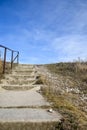 Ladder going up. Staircase made of concrete steps against the blue sky. Railings from metal pipes. Climbing up. Close-up. Royalty Free Stock Photo