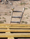 A ladder leaned against the roof frame done with wooden trusses, braces, and roof beams