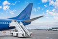 Ladder ladder at the rear entrance of a passenger aircraft, view of the tail and apron of the airport