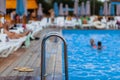 the stainless steel railing of the stairs by the pool with water Royalty Free Stock Photo