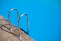 the stainless steel railing of the stairs by the pool with water Royalty Free Stock Photo