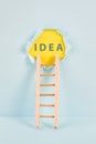 Ladder of success, having an idea, marketing and business concept, brainstorming for new goals, light bulb around torn paper Royalty Free Stock Photo