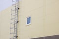 Ladder to the roof of a tall building and window on a dark sky background Royalty Free Stock Photo