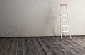 Ladder on the wooden floor amid the old wall Royalty Free Stock Photo