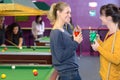 Ladies chatting with drinks in pool hall Royalty Free Stock Photo