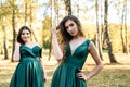 Ladies in elegant green dresses walking in autumn park. Brunette girl Dreamy young girls laughing on the outdoors