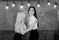 Ladies in formal wear on happy faces, chalkboard on background. Pass exam concept. Attractive students congrats each