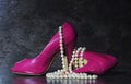 Ladies pink high heels with long strand of white pearls Royalty Free Stock Photo