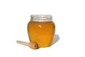 Fresh honey in a jar with a wooden dipper on a white isolated background. Royalty Free Stock Photo