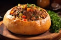 ladling beef stew into a bread bowl Royalty Free Stock Photo