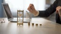 Lady adding coin to stack on office desk, bank earning interests, repaying loan