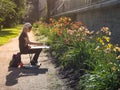 Lady artist paints a picture among the flowers in the Park. Botanical garden. Saint-Petersburg. The summer of 2017.