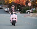 Lady biker on pink scooter Royalty Free Stock Photo