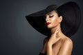 Lady in Black Hat with Red Lipstick Make up. Elegant Woman with Face Makeup and Nails Manicure over Dark Gray. Beautiful Model