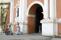 Lady, Blind Man beside disabled Beggar in wheelchair at Church yard Gate Portal