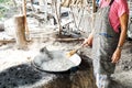 Lady boiled sugar from sugar palm in pan. Boiled water. Chew sugar. Outdoor cooking.