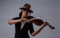 The lady with brown hat is playing violin,put the violin on left shoulder and hold bow violin with right hand Royalty Free Stock Photo