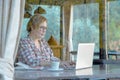 Lady browsing Internet on Portable Computer in Cafe