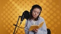 Lady browsing pages, doing voiceover reading of book to produce audiobook