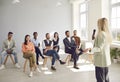 Lady business coach conducts a presentation, trains a team for a multi-racial group of young people Royalty Free Stock Photo