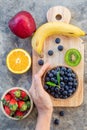 Blueberries on wooden board with multi fruit from top view