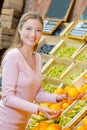 Lady choosing oranges in grocers Royalty Free Stock Photo