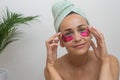 lady, in close-up, applies eye patches her facial beauty regimen, savoring a tranquil spa day. Royalty Free Stock Photo