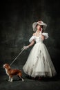 Lady with dog. Vintage portrait of young elegant woman in image of medieval person in renaissance style dress isolated Royalty Free Stock Photo