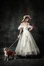 Lady with dog. Vintage portrait of young elegant woman in image of medieval person in renaissance style dress isolated Royalty Free Stock Photo