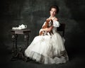 Lady with dog. Vintage portrait of young elegant woman in image of medieval person in renaissance style dress Royalty Free Stock Photo