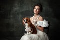 Lady with dog. Vintage portrait of young elegant woman in image of medieval person in renaissance style dress Royalty Free Stock Photo