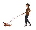 Lady with a dog. A young woman leads a dachshund dog on a leash