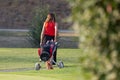 Lady Dressed in Red Who Walked Away on the Golf Course with the Cart Containing her equipment: Balls and Clubs
