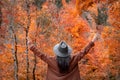 Lady dressed in stylish fall outfits walking in the forest on a colorful fall day