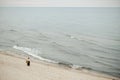 Lady enjoying sea noise while strolling along shore Royalty Free Stock Photo