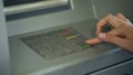 Lady entering PIN number to check bank account and withdraw money from ATM