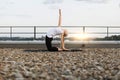 Lady exercising back-bend pose while kneeling on gravel roof