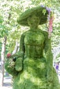 Lady figure made of trimmed bush on natural background
