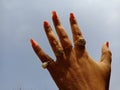 Lady fingers with diamonds ring on hand isolated at sky background