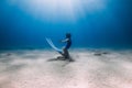 Lady freediver posing underwater at the deep in blue sea with sunlight Royalty Free Stock Photo