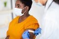 Lady Getting Vaccinated While Doctor Applying Plaster After Injection Indoors