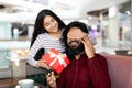 Lady giving her boyfriend birthday, anniversary gift in cozy cafe Royalty Free Stock Photo