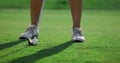 Lady golfer legs training wear white sneakers at country club course grass field Royalty Free Stock Photo