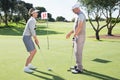 Lady golfer on the putting green at the eighteenth hole with partner Royalty Free Stock Photo