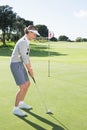 Lady golfer on the putting green at the eighteenth hole Royalty Free Stock Photo