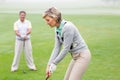 Lady golfer teeing off for the day watched by partner Royalty Free Stock Photo