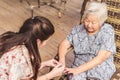 Lady having her nails painted by a younger girl